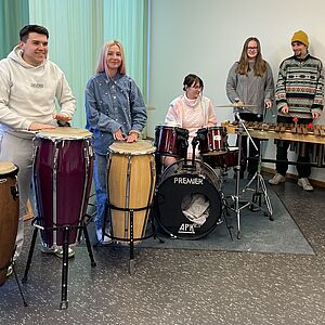 Schüler:innen stehen im Halbkreis und musizieren gemeinsam